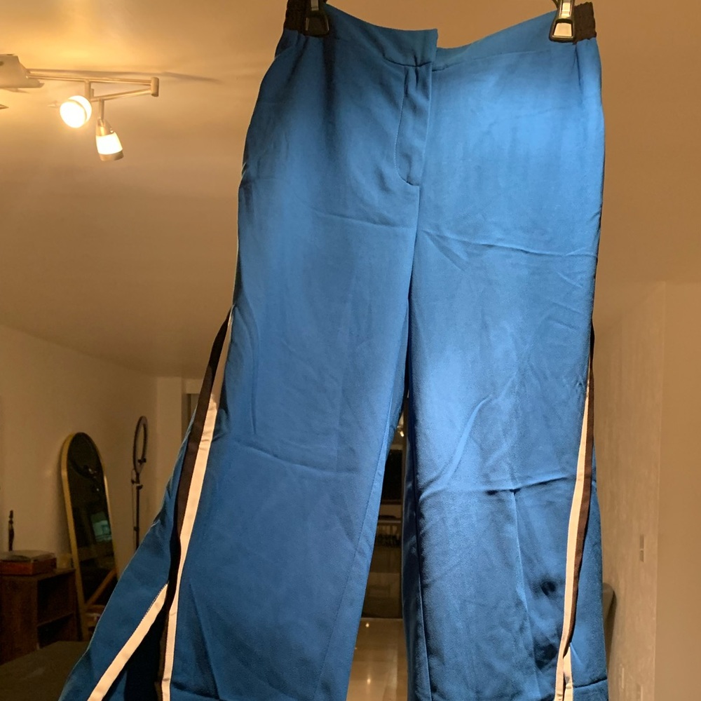 New with tags. Nicole Miller pants with stripes and slips on the sides.